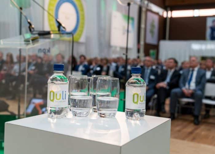 Flesjes water met Quli logo op een event - samenwerken